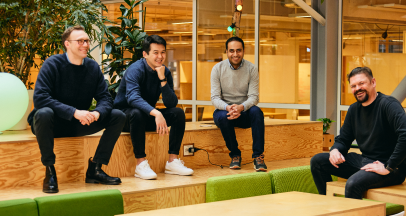 Kosli team smiling and sitting on benches